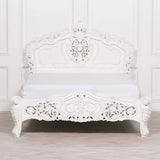 White ornate carved bed frame with intricate headboard and footboard, classic bedroom style
