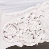 White carved wood bed frame with ornate floral detailing