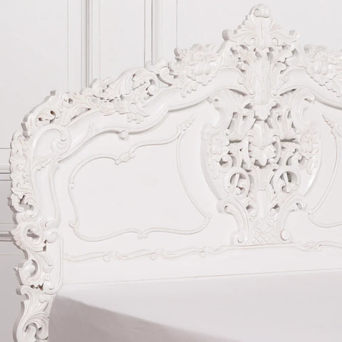 White carved wooden headboard with ornate floral detailing and classic paneling