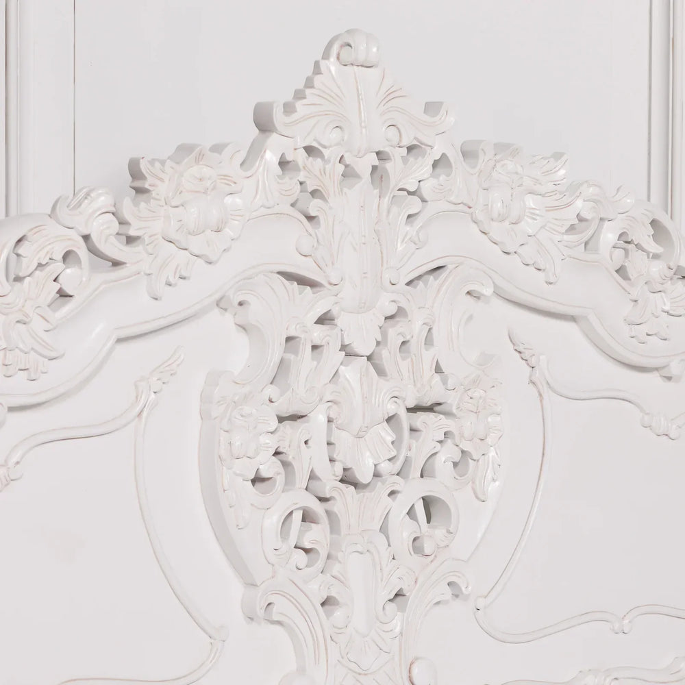 White carved wooden headboard with ornate floral detailing and traditional scrollwork