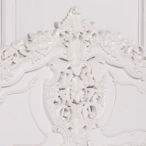 White carved wooden headboard with ornate floral detailing and traditional scrollwork