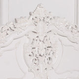 White carved wooden headboard with ornate floral detailing and traditional scrollwork
