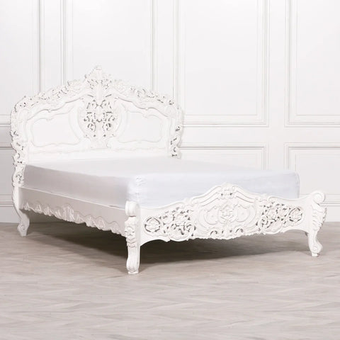 White carved bed frame with ornate headboard and footboard in classic style