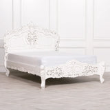 White carved bed frame with ornate headboard and footboard in classic style