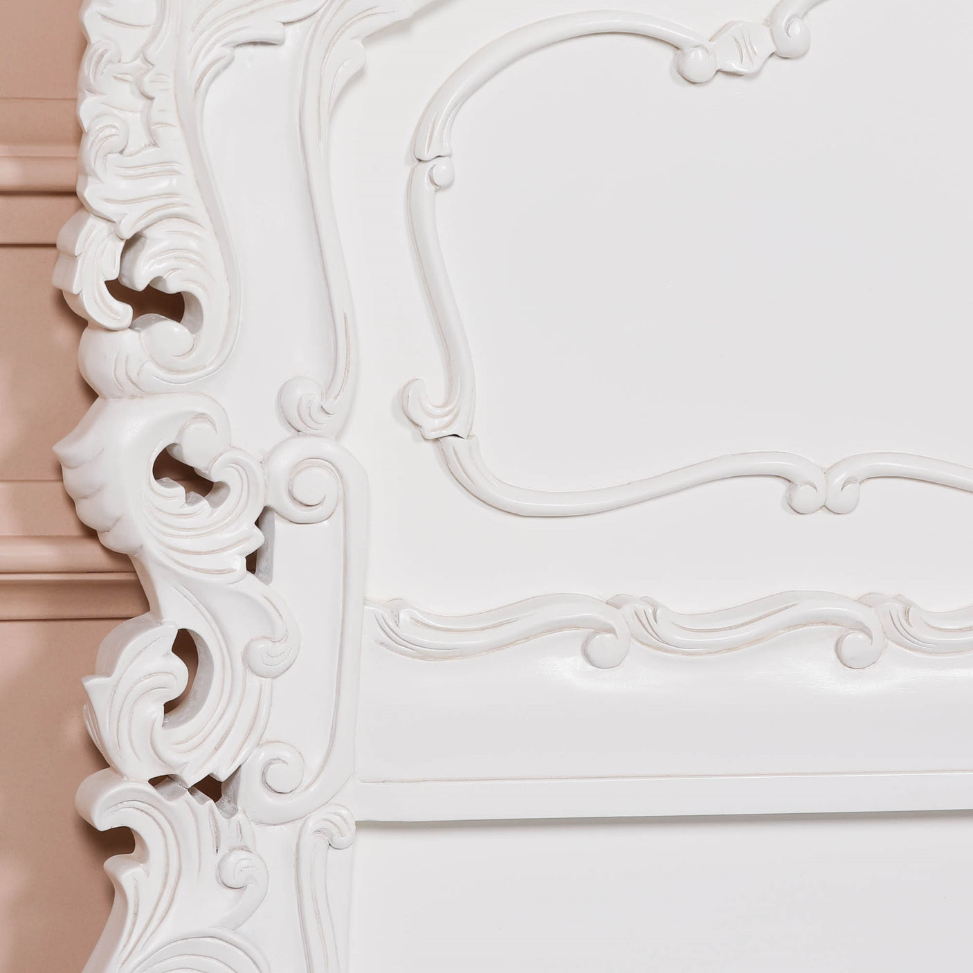 Close-up of an ornate white frame with intricate detailing.
