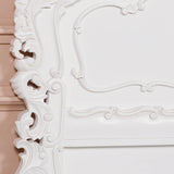 Close-up of an ornate white frame with intricate detailing.