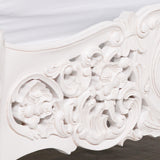 Close-up of an ornate white decorative element with intricate carvings on a plain background