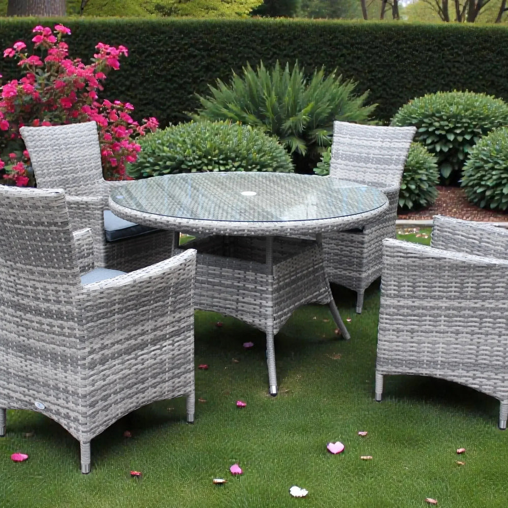 Grey rattan dining set with round glass table and four chairs on garden lawn