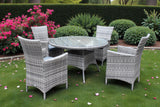 Grey rattan dining set with round glass table and four chairs on garden lawn