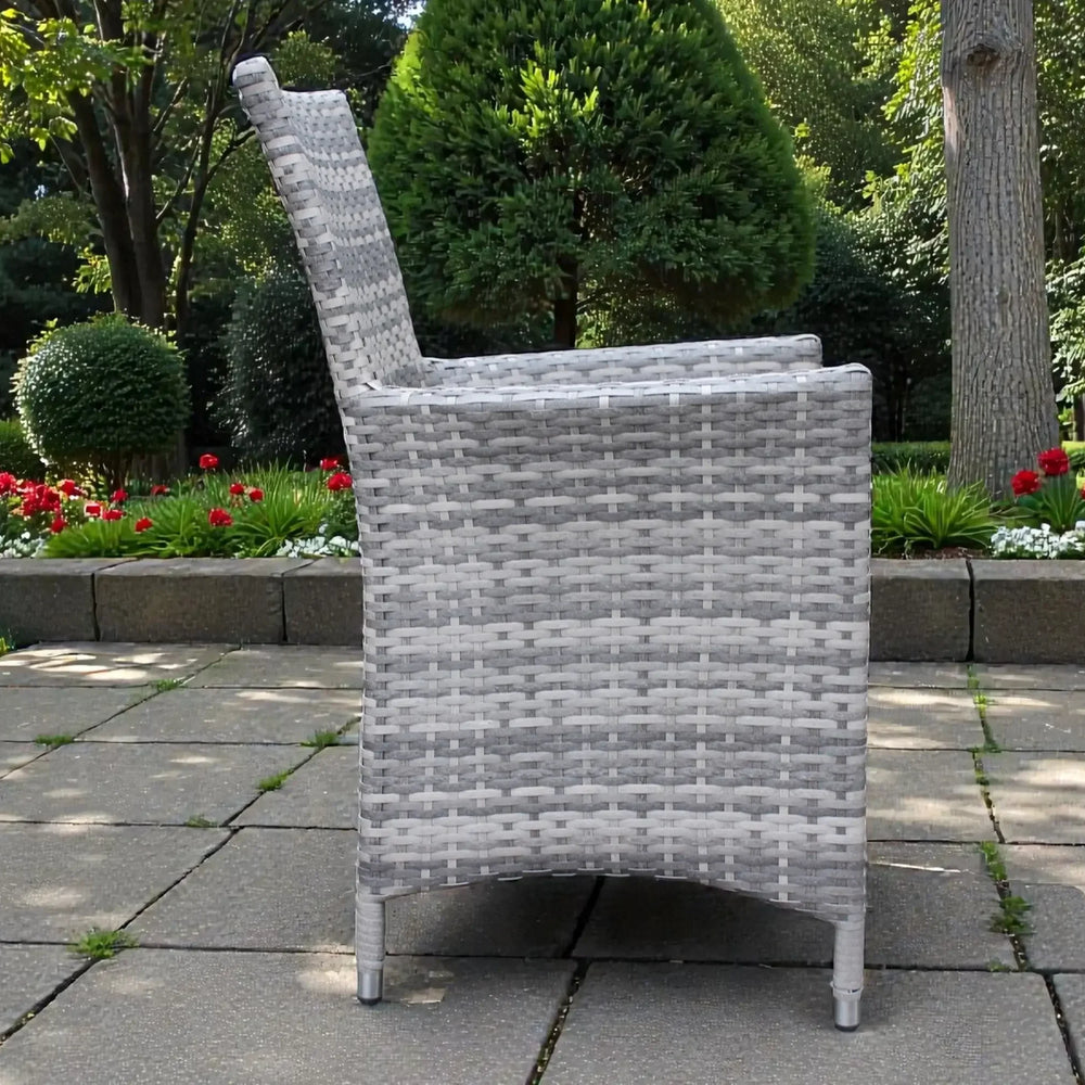 Grey rattan dining chair side view on patio with garden background