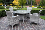 Grey rattan dining set with round glass table and four chairs on patio in garden setting