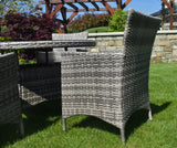 Grey rattan outdoor dining set with chairs and round table on grass garden lawn