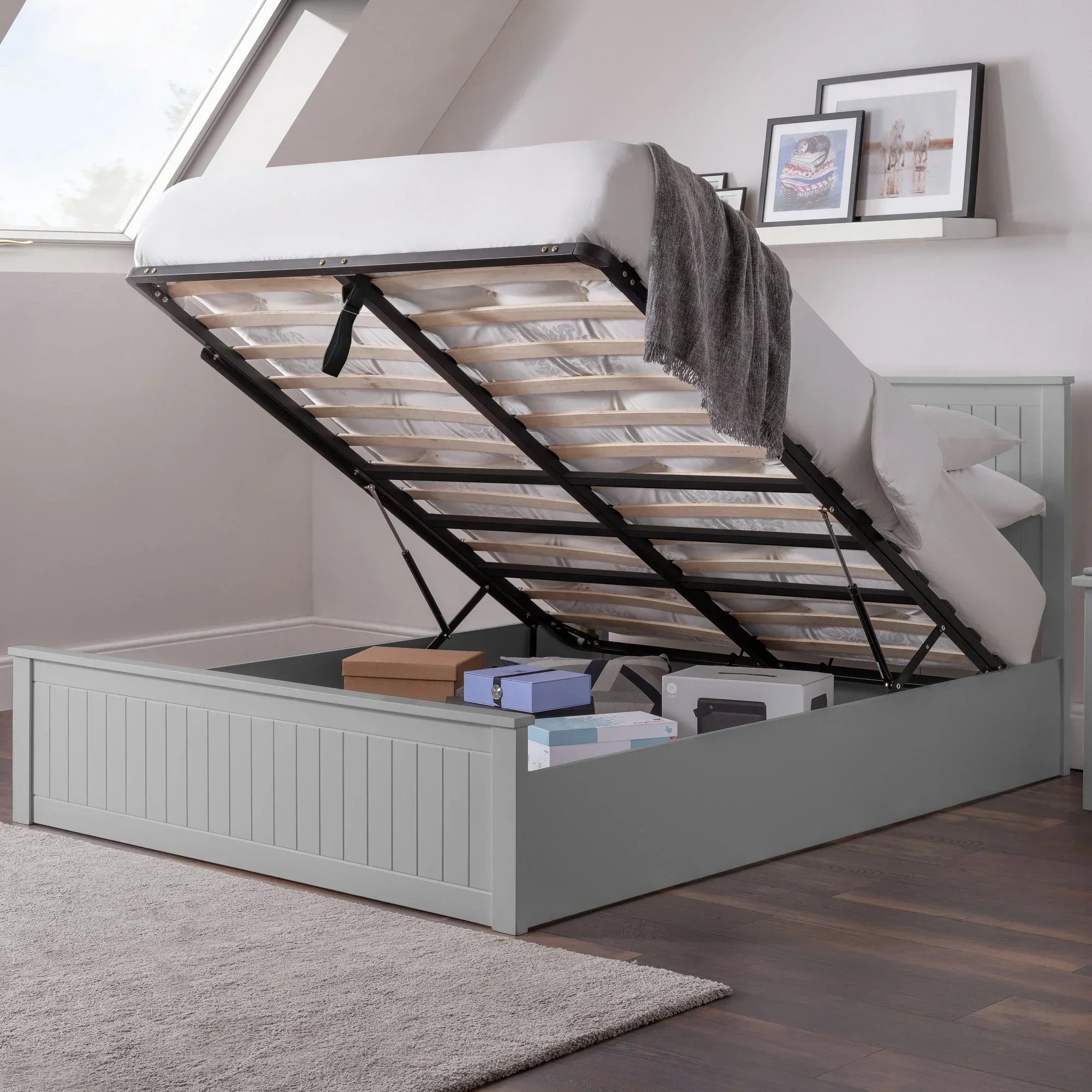 Dove grey ottoman bed open showing underbed storage with boxes in modern bedroom