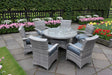 Grey rattan dining set with glass round table and six cushioned chairs on garden patio
