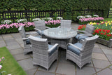 Grey rattan dining set with glass round table and six cushioned chairs on garden patio