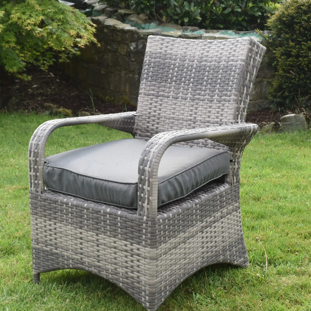 Grey rattan garden dining chair with cushion on lawn