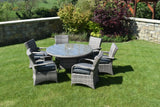 Grey rattan dining set with six cushioned chairs and glass top table on lawn garden