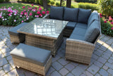 Rattan corner garden sofa set with glass top table and grey cushions on stone patio