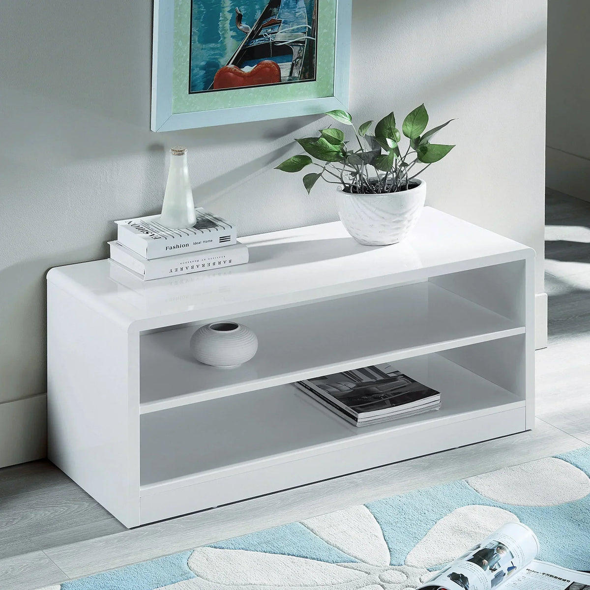 White gloss compact TV unit with open shelves, potted plant and books in modern living room