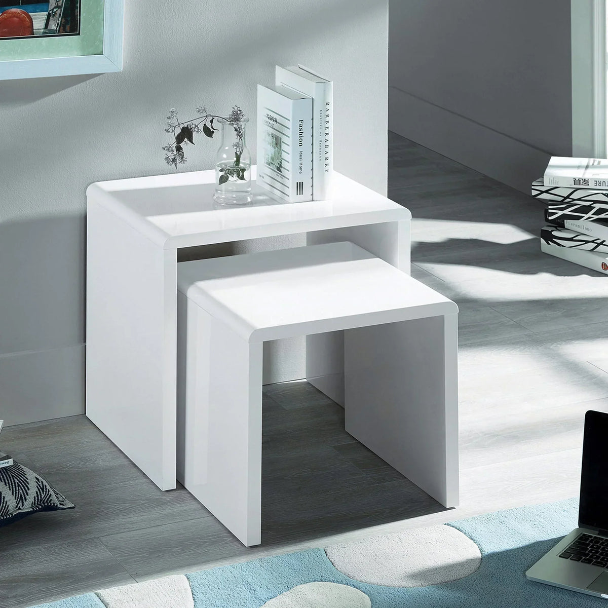 White gloss nest of tables in modern room with books and glass vase on top