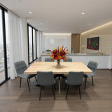 Oak dining table with grey PU chairs in modern kitchen, floral centerpiece on tabletop
