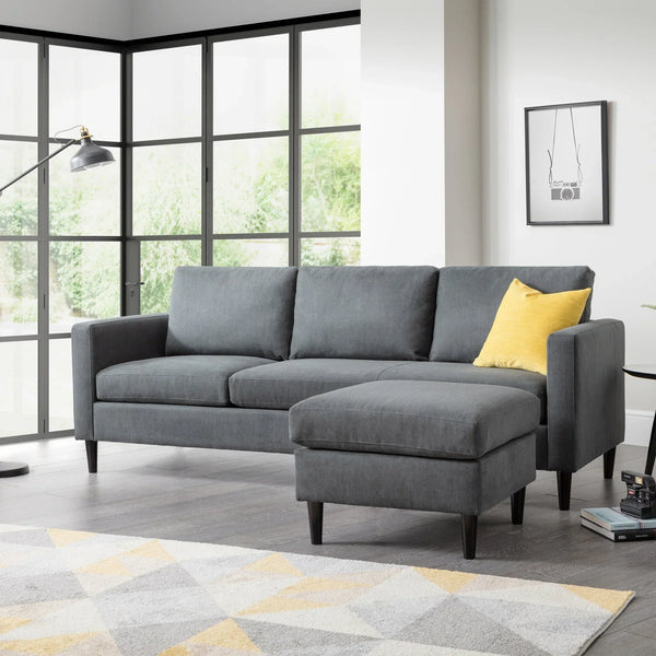 Grey corner sofa with matching ottoman and yellow cushion in modern living room setting
