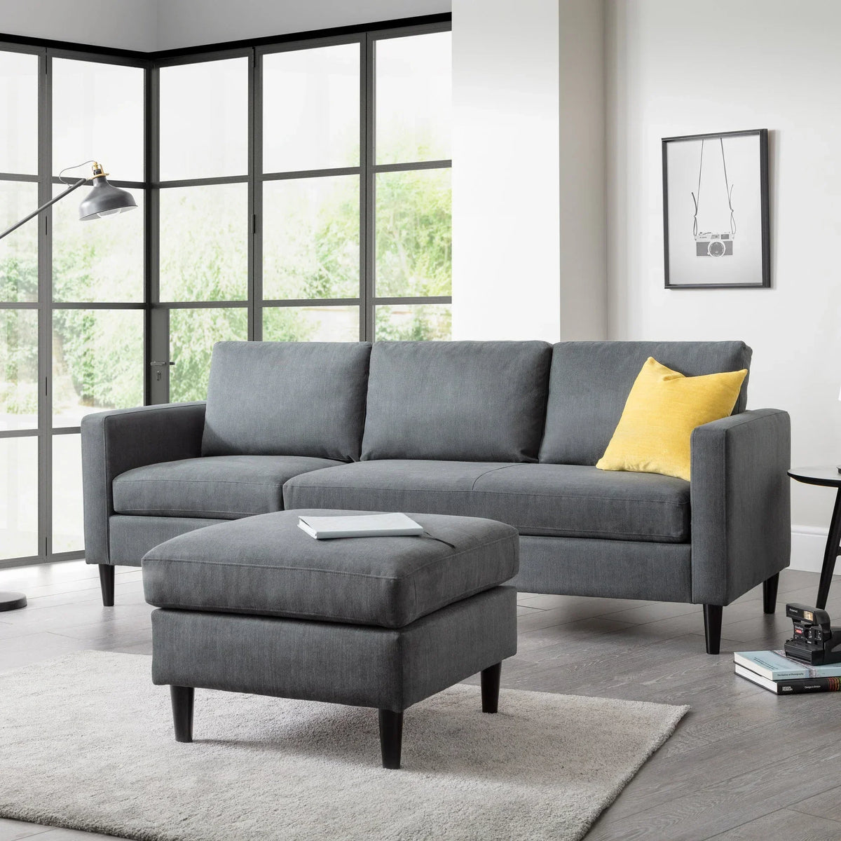 Charcoal corner sofa with ottoman and yellow cushion in modern living room setting