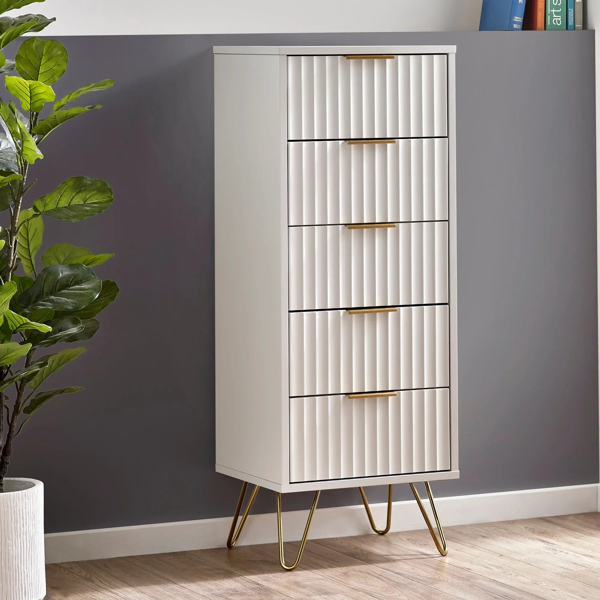 White tallboy chest of drawers with gold handles and metal legs in modern room