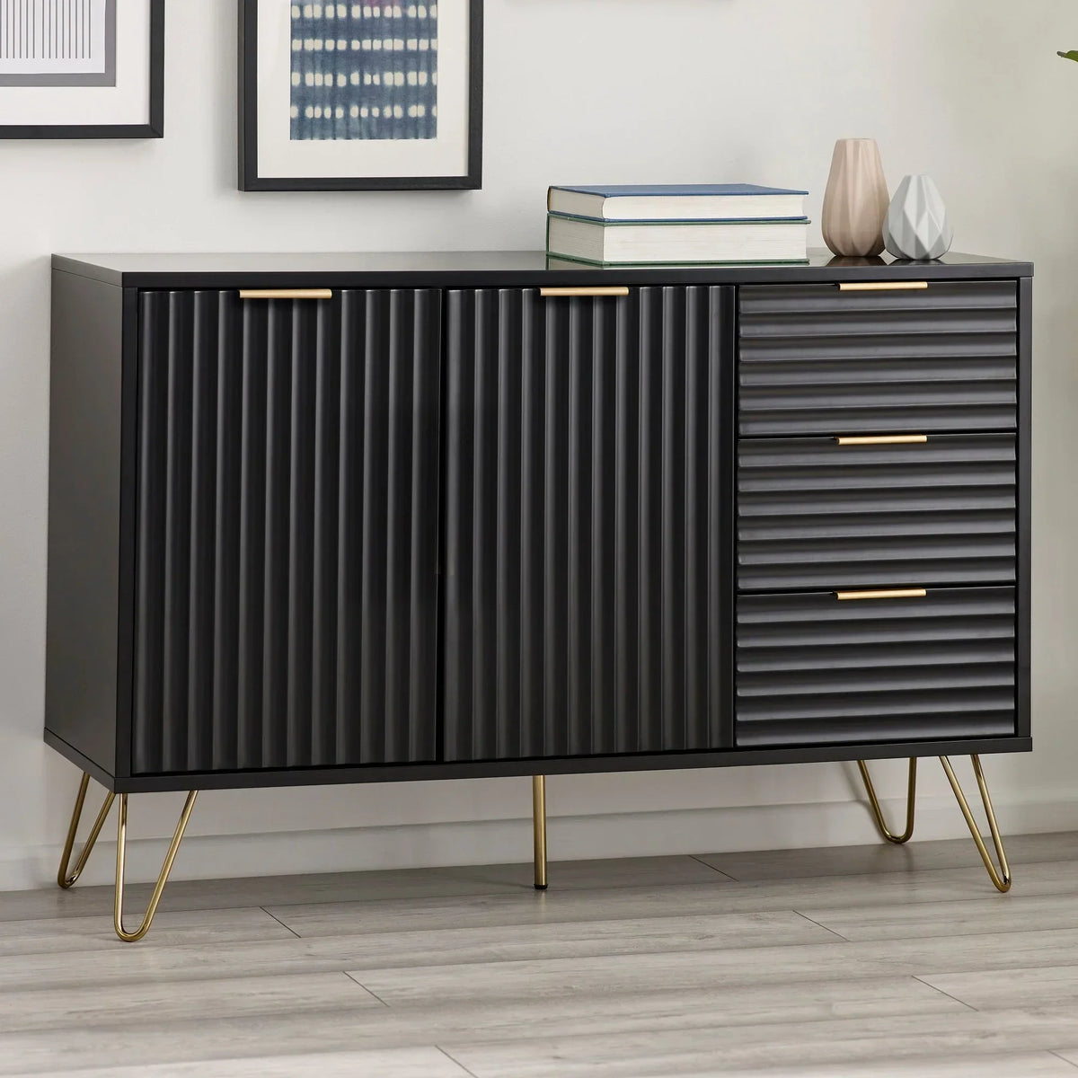 Black sideboard with gold handles, ribbed doors and drawers, standing on gold legs