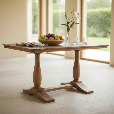 Wooden dining table with fruit bowl and flowers in a bright room