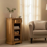 Wooden side table with a vase and books next to a beige armchair in a softly lit room.