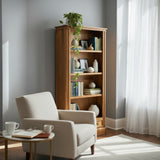 Living room with a beige armchair, wooden bookshelf, and a window with white curtains.