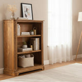 Wooden bookshelf in a room with decor items and a lamp.