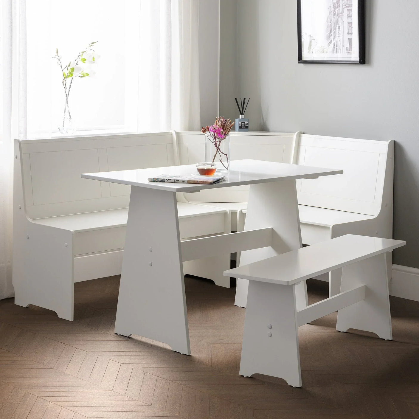 White corner dining set with bench and table in modern room with wood herringbone floor