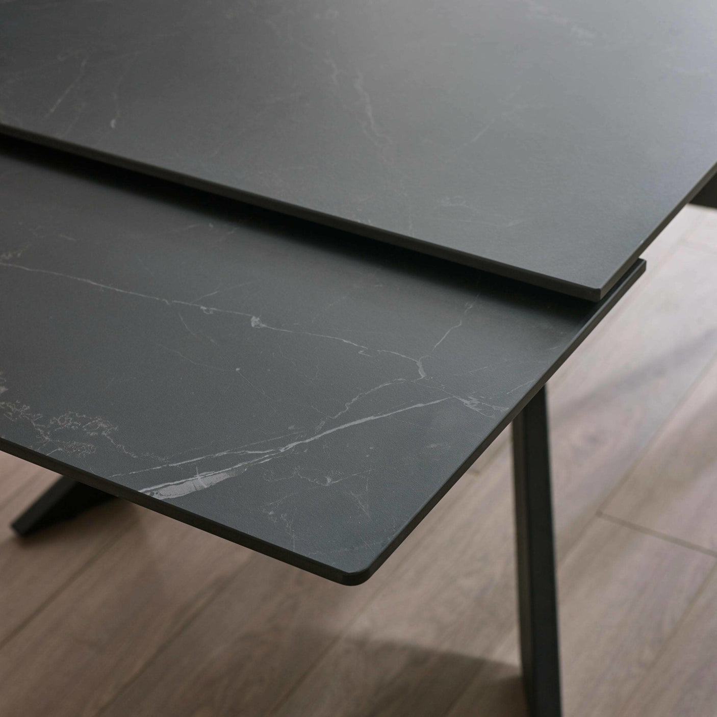 Close-up showing extended table top pieces with black marble pattern and clean edges