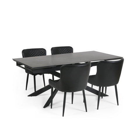 Black extending dining table with four black leather upholstered chairs featuring quilted backs.