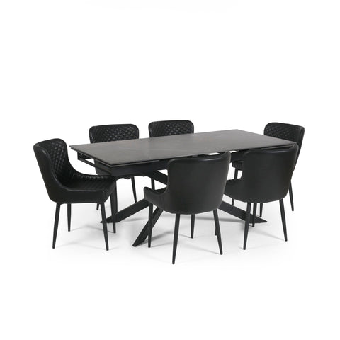 Extended black dining table with six black leather chairs, viewed from an angle on white background.