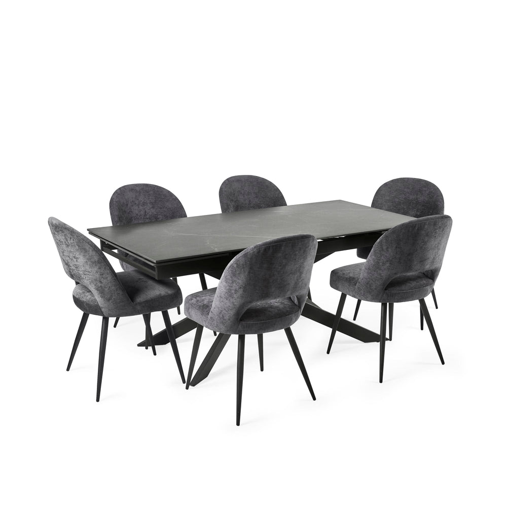 Modern black extending dining table with six grey velvet chairs in a grey-themed room setting.