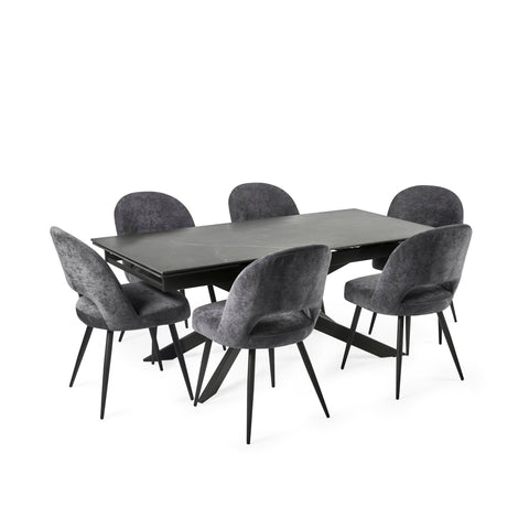Modern black extending dining table with six grey velvet chairs in a grey-themed room setting.