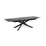Extended matte black dining table with crossed metal base, isolated on white background, side view