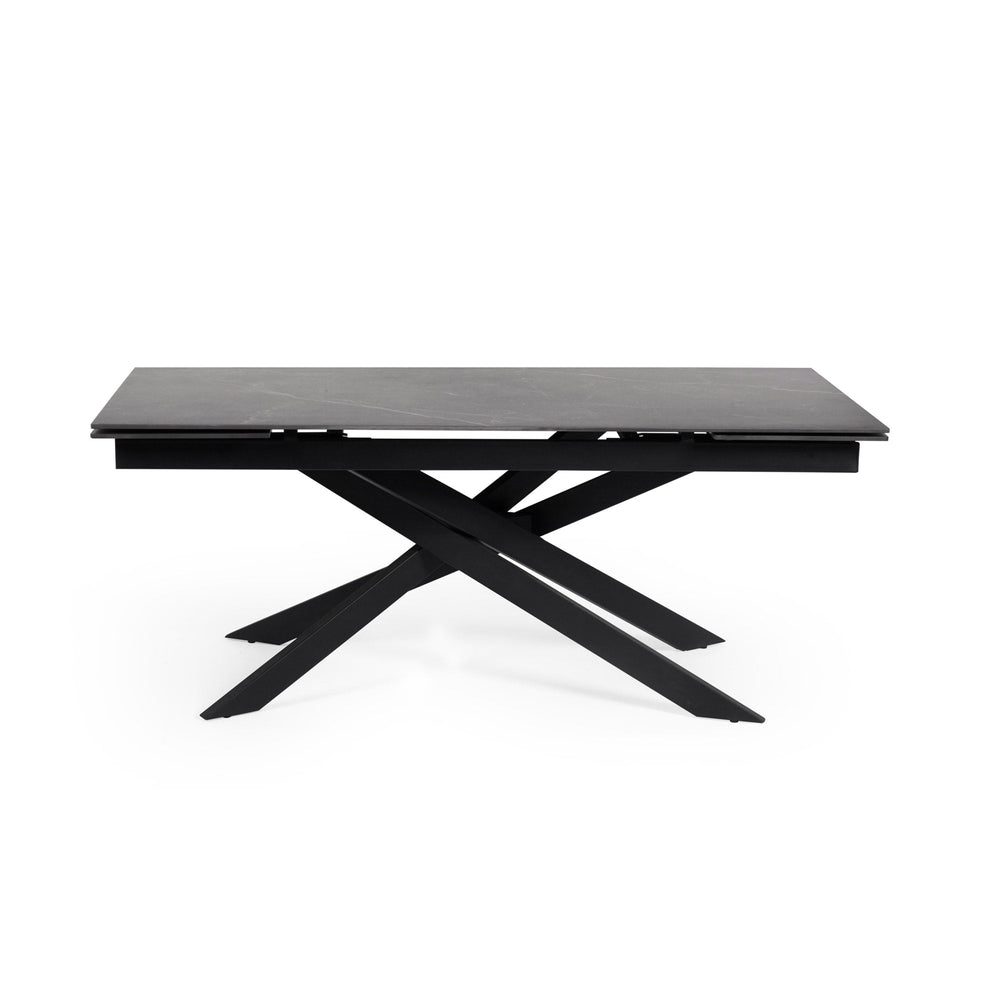 Rectangular dining table with black marble top and black crossed metal legs, side view isolated on white