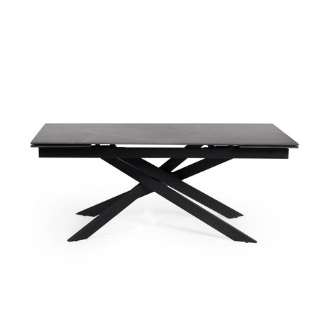 Rectangular dining table with black marble top and black crossed metal legs, side view isolated on white