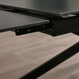 Close-up of black marble tabletop edge and metal frame mechanism for extending the table
