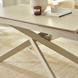 Close-up of light beige tabletop with wood-like texture and stacked candles and books on table corner