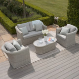 Light grey rattan garden furniture set with cushions and oval coffee table on patio decking