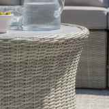 round rattan outdoor coffee table with glass jug and bowl, close-up of woven texture