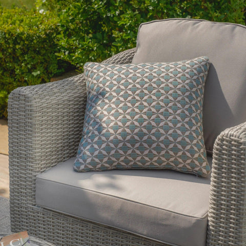 Grey rattan garden armchair with geometric patterned outdoor cushion on patio