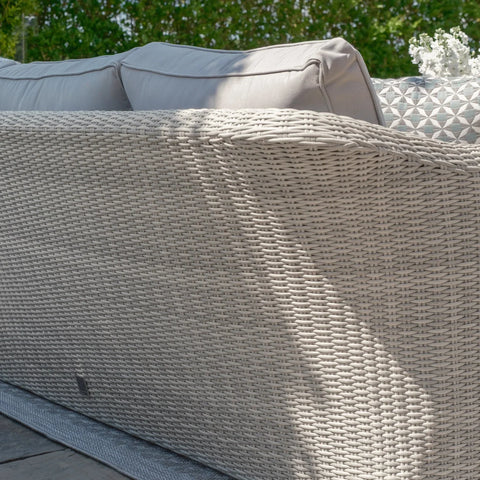 Light grey rattan garden sofa with textured weave and outdoor cushions