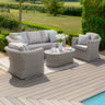 Light grey rattan outdoor sofa set with cushions and coffee table on a deck by the garden