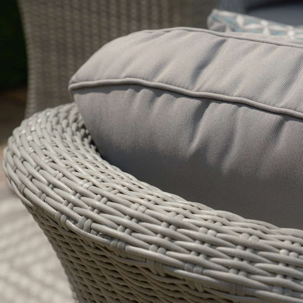 Close-up of grey rattan garden chair with padded outdoor cushion